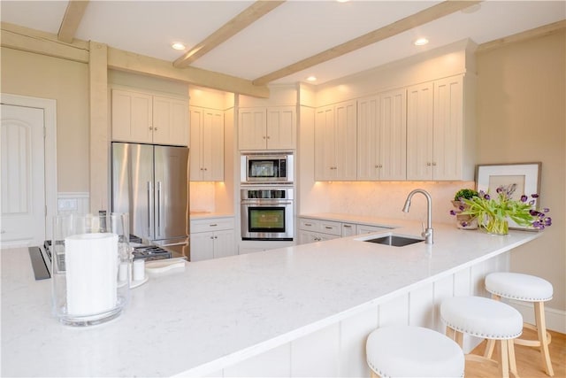 62 James Ct, Portsmouth, RI 02871 - kitchen featuring appliances with stainless steel finishes, beam ceiling, light countertops, a peninsula, and recessed lighting