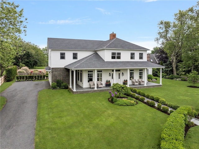 62 James Ct, Portsmouth, RI 02871 - view of front of property with a chimney, driveway, roof with shingles, stone siding, and a front yard