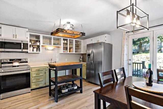 47 Morgan Ave Unit 45, Johnston, RI 02919 - kitchen with stainless steel appliances, open shelves, light countertops, backsplash, and a chandelier