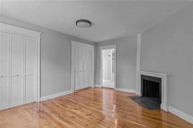 529 Rocky Hill Rd, Scituate, RI 02857 - unfurnished living room featuring a fireplace with flush hearth, wood finished floors, and baseboards