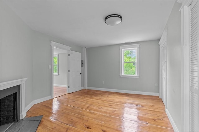529 Rocky Hill Rd, Scituate, RI 02857 - unfurnished living room featuring light wood-type flooring, a fireplace with flush hearth, and baseboards
