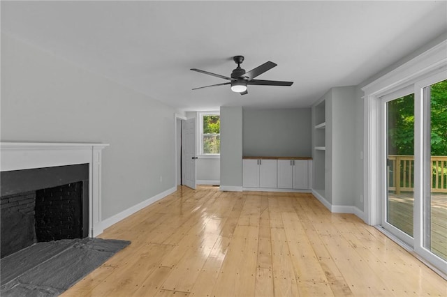 529 Rocky Hill Rd, Scituate, RI 02857 - unfurnished living room with light wood finished floors, ceiling fan, baseboards, and a fireplace with flush hearth