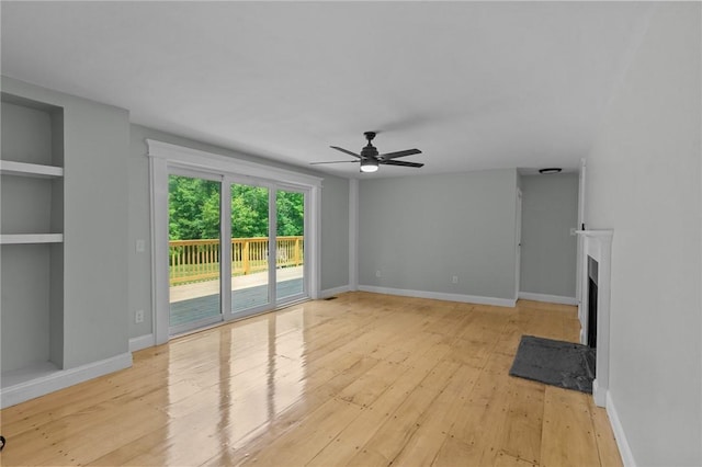 529 Rocky Hill Rd, Scituate, RI 02857 - unfurnished living room with ceiling fan, light wood-style flooring, a fireplace, and built in shelves