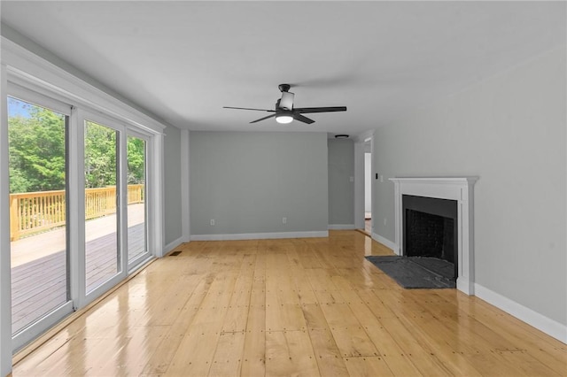 529 Rocky Hill Rd, Scituate, RI 02857 - unfurnished living room with light wood-type flooring, a ceiling fan, a fireplace with flush hearth, and baseboards