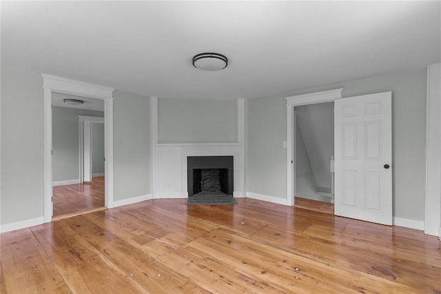 529 Rocky Hill Rd, Scituate, RI 02857 - unfurnished living room with light wood-type flooring, a fireplace with flush hearth, and baseboards