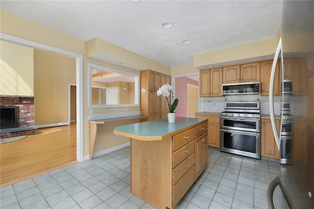 30 Walden Way S, Kingstown, RI 02879 - kitchen with appliances with stainless steel finishes, baseboard heating, a kitchen island, light tile patterned floors, and backsplash