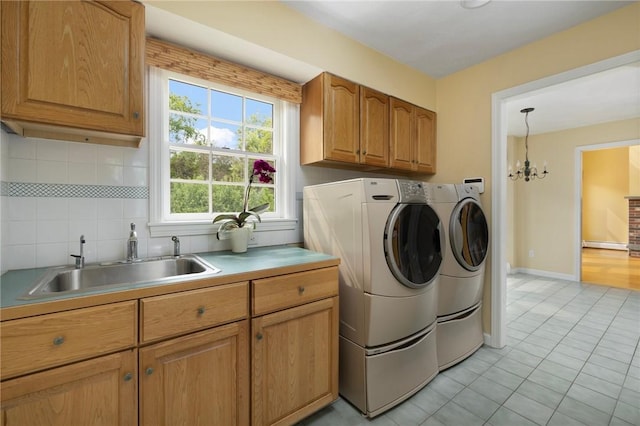 30 Walden Way S, Kingstown, RI 02879 - laundry area featuring cabinet space, washing machine and dryer, light tile patterned floors, a chandelier, and baseboards