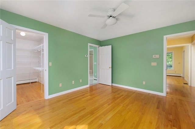 30 Walden Way S, Kingstown, RI 02879 - unfurnished bedroom with a baseboard heating unit, a walk in closet, light wood-type flooring, and baseboards
