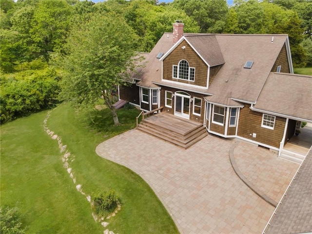 30 Walden Way S, Kingstown, RI 02879 - rear view of house featuring a chimney, a lawn, a shingled roof, and a deck