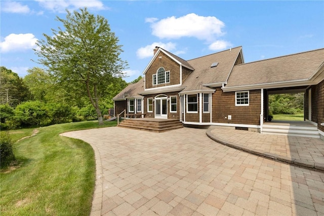 30 Walden Way S, Kingstown, RI 02879 - back of property featuring a patio area, a lawn, a shingled roof, and a deck