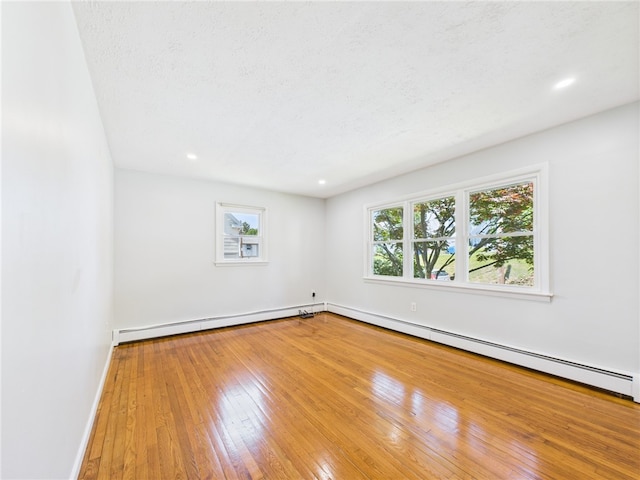 5 Conca St, North Providence, RI 02904 - empty room featuring baseboards, baseboard heating, hardwood / wood-style floors, recessed lighting, and a textured ceiling