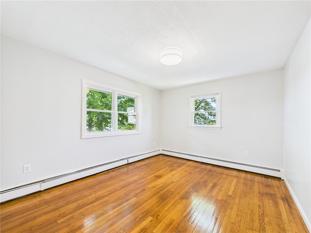 5 Conca St, North Providence, RI 02904 - spare room featuring baseboard heating, wood-type flooring, and baseboards