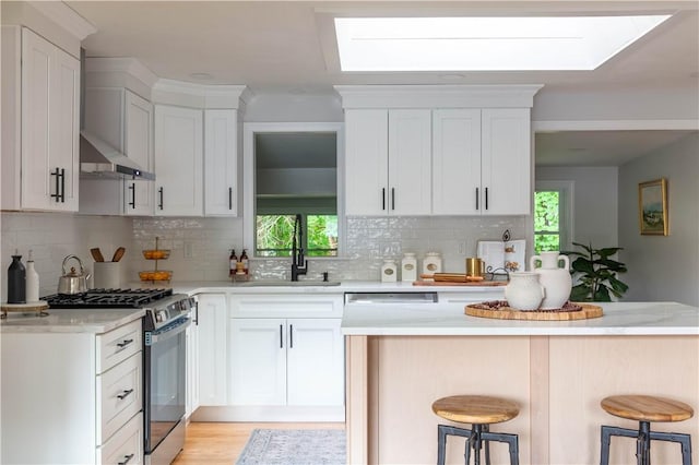24 W Knollwood Cir, North Kingstown, RI 02852 - kitchen with appliances with stainless steel finishes, a sink, light countertops, a kitchen bar, and backsplash