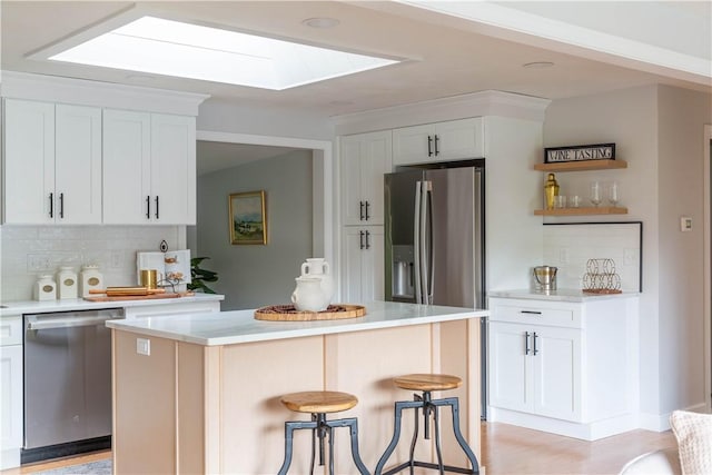 24 W Knollwood Cir, North Kingstown, RI 02852 - kitchen featuring appliances with stainless steel finishes, a skylight, tasteful backsplash, and white cabinets