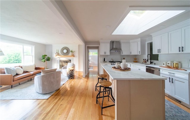 24 W Knollwood Cir, North Kingstown, RI 02852 - kitchen featuring wall chimney exhaust hood, dishwasher, open floor plan, a sink, and a breakfast bar