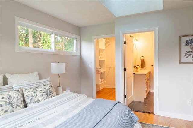 24 W Knollwood Cir, North Kingstown, RI 02852 - bedroom with light wood-style flooring, a sink, ensuite bathroom, and baseboards