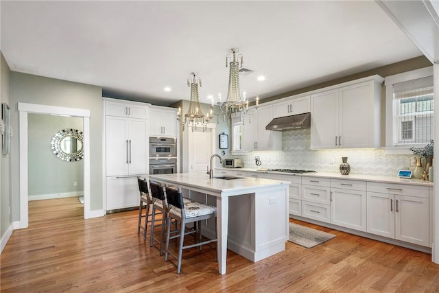 171 Leeshore Ln, Tiverton, RI 02878 - kitchen with a sink, a chandelier, backsplash, a kitchen island with sink, and a kitchen bar