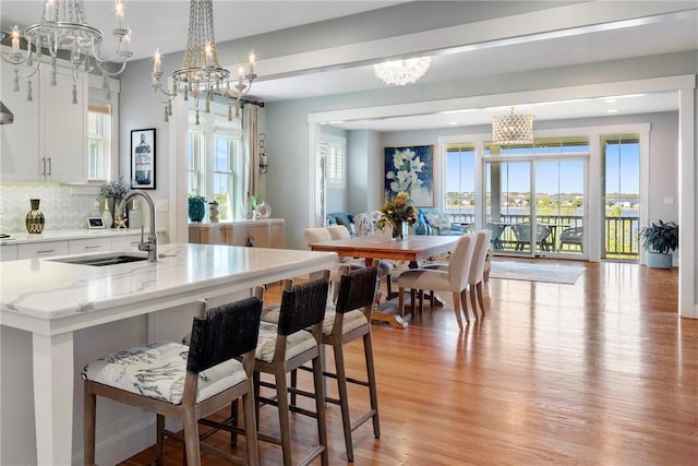 171 Leeshore Ln, Tiverton, RI 02878 - kitchen featuring a chandelier, light wood-style floors, plenty of natural light, and a sink