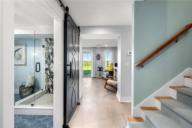 171 Leeshore Ln, Tiverton, RI 02878 - entrance foyer with a barn door, stairway, and light wood-style floors