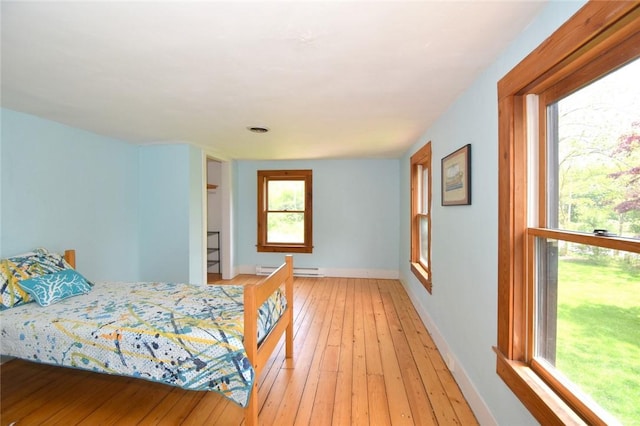 259 Green Hill Beach Rd, South Kingstown, RI 02879 - bedroom with baseboard heating, baseboards, and light wood-type flooring