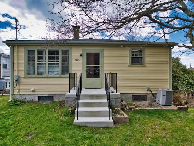 127 Pettey Ln, Westport, MA 02790 - back of house with central air condition unit, a lawn, and a chimney