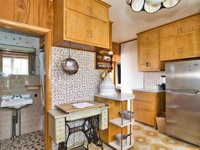 127 Pettey Ln, Westport, MA 02790 - kitchen featuring freestanding refrigerator, backsplash, light tile patterned floors, light countertops, and brown cabinets