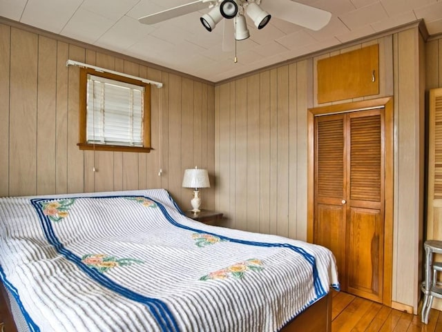 127 Pettey Ln, Westport, MA 02790 - bedroom featuring light wood-type flooring, a closet, wood walls, and a ceiling fan