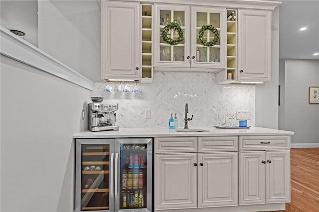 40 Oakbrook Ct, East Greenwich, RI 02818 - indoor wet bar with beverage cooler, tasteful backsplash, light wood-style floors, and baseboards