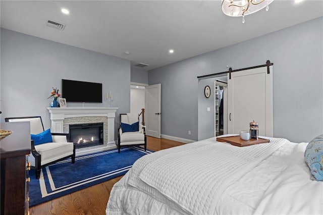 40 Oakbrook Ct, East Greenwich, RI 02818 - bedroom with wood finished floors, a fireplace, recessed lighting, a barn door, and baseboards