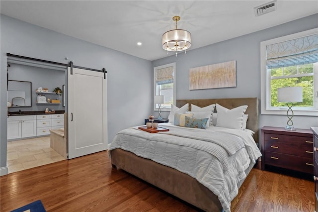 40 Oakbrook Ct, East Greenwich, RI 02818 - bedroom with a barn door, multiple windows, light wood finished floors, and recessed lighting