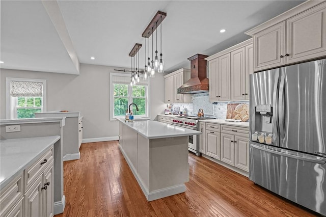 40 Oakbrook Ct, East Greenwich, RI 02818 - kitchen with stainless steel appliances, wall chimney exhaust hood, light countertops, backsplash, and an island with sink