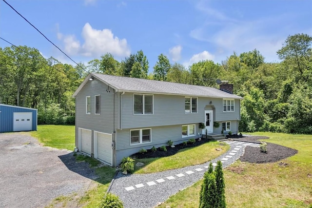 202 Hartford Pike, Foster, RI 02825 - view of front of house featuring a chimney, a front yard, a garage, driveway, and an outbuilding