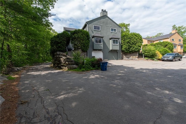 15 Loyalist Dr Unit 15B, Uxbridge, MA 01569 - view of front of property with stucco siding and a chimney