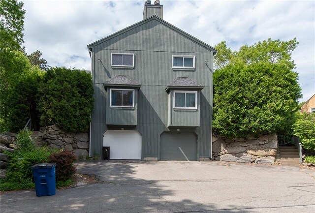 15 Loyalist Dr Unit 15B, Uxbridge, MA 01569 - back of house featuring a garage, asphalt driveway, stairs, and a chimney