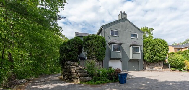 15 Loyalist Dr Unit 15B, Uxbridge, MA 01569 - view of front facade featuring stucco siding and a chimney