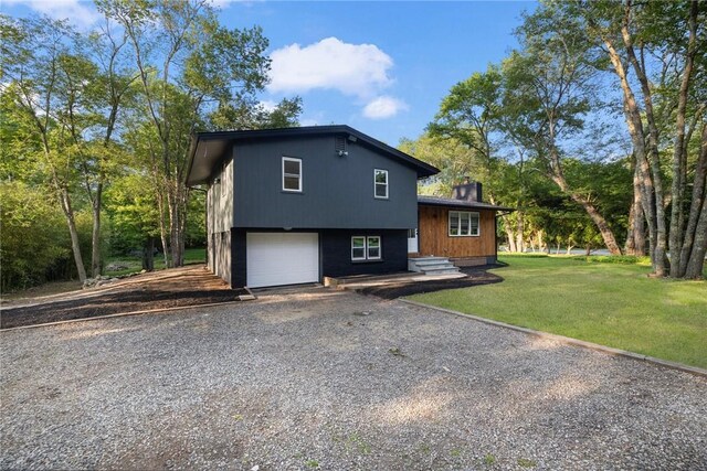 7 Nichols Rd, South Kingstown, RI 02881 - tri-level home featuring driveway, a garage, and a front lawn