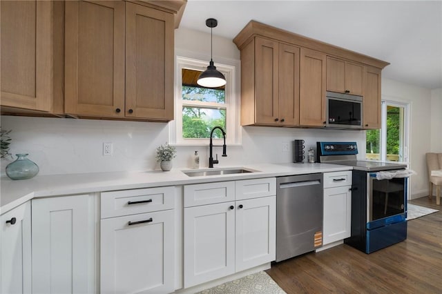 7 Nichols Rd, South Kingstown, RI 02881 - kitchen with appliances with stainless steel finishes, a sink, dark wood-style floors, pendant lighting, and light countertops