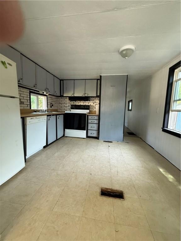 6101 Post Rd, North Kingstown, RI 02852 - kitchen featuring white appliances, backsplash, gray cabinetry, and dark countertops