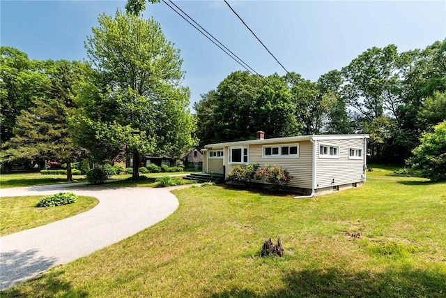7 Stuart St, Westerly, RI 02891 - rear view of house featuring a yard, view of wooded area, and a chimney