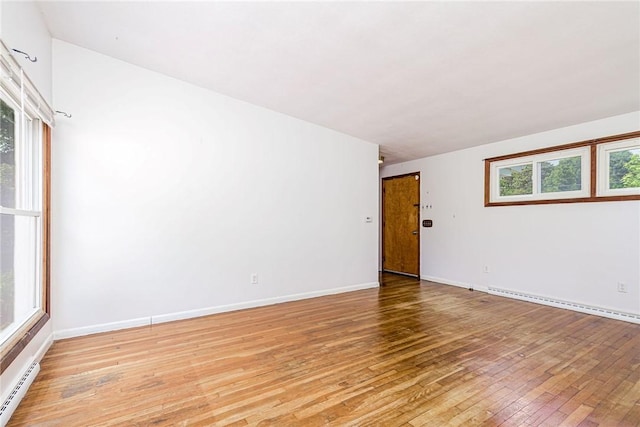 7 Stuart St, Westerly, RI 02891 - empty room featuring a baseboard radiator, light wood-style flooring, and healthy amount of natural light