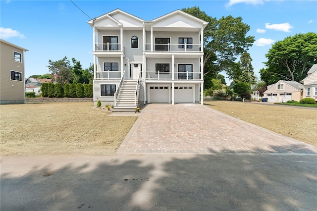 41 Burnett Rd, Warwick, RI 02889 - view of front of property featuring a balcony, decorative driveway, stairway, an attached garage, and a front lawn