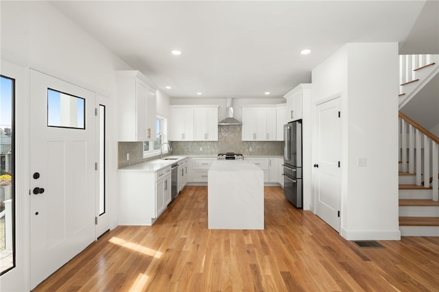 41 Burnett Rd, Warwick, RI 02889 - kitchen featuring appliances with stainless steel finishes, a sink, wall chimney exhaust hood, light countertops, and a center island