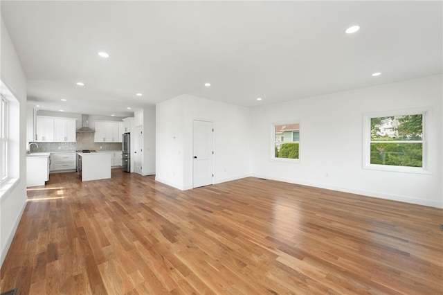 41 Burnett Rd, Warwick, RI 02889 - unfurnished living room featuring recessed lighting, light wood-type flooring, baseboards, and a sink