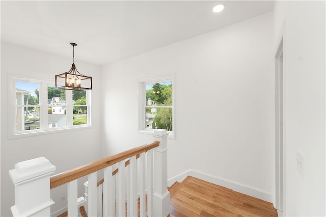 41 Burnett Rd, Warwick, RI 02889 - hallway featuring healthy amount of natural light, an upstairs landing, light wood-style flooring, a chandelier, and recessed lighting
