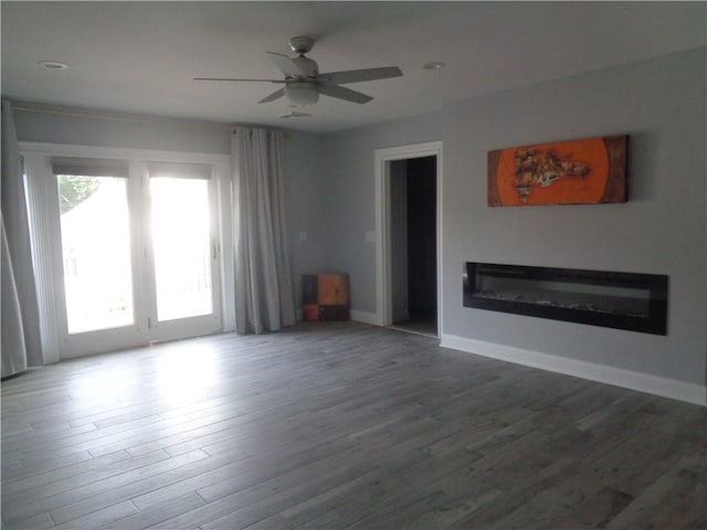 176 Vernon St, Warwick, RI 02889 - unfurnished living room featuring wood finished floors, ceiling fan, a glass covered fireplace, and baseboards