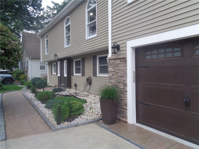176 Vernon St, Warwick, RI 02889 - property entrance featuring an attached garage and stone siding