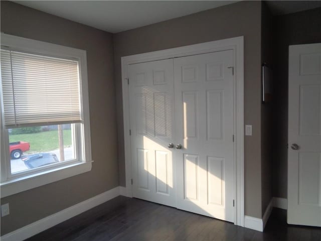 176 Vernon St, Warwick, RI 02889 - unfurnished bedroom featuring dark wood-style floors, baseboards, and a closet