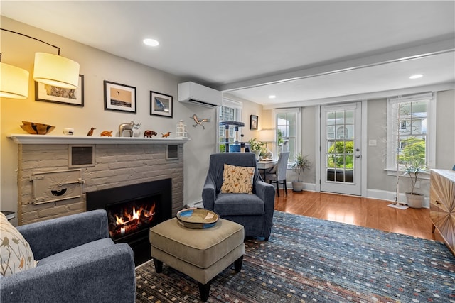 37 Brownell St, Warren, RI 02885 - living room featuring an AC wall unit, wood finished floors, a fireplace, baseboards, and recessed lighting