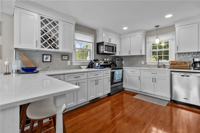 37 Brownell St, Warren, RI 02885 - kitchen featuring stainless steel appliances, white cabinetry, wood finished floors, backsplash, and recessed lighting