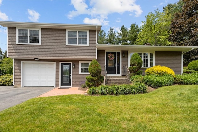 1221 Phenix Ave, Cranston, RI 02921 - split level home featuring a front yard, an attached garage, and driveway